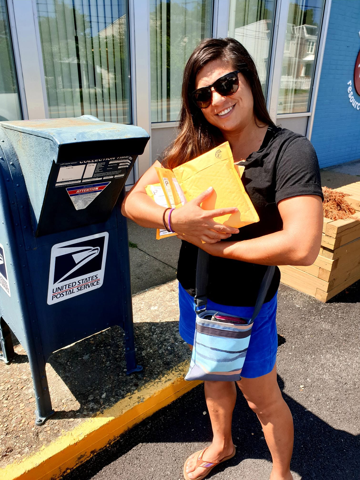 Elizabeth Roach Cain carrying seed-care packages to a postal collection box