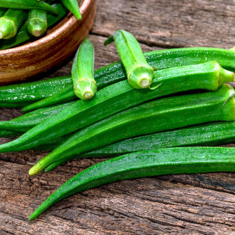 Cow Horn okra pods arranged on a rustic wooden surface