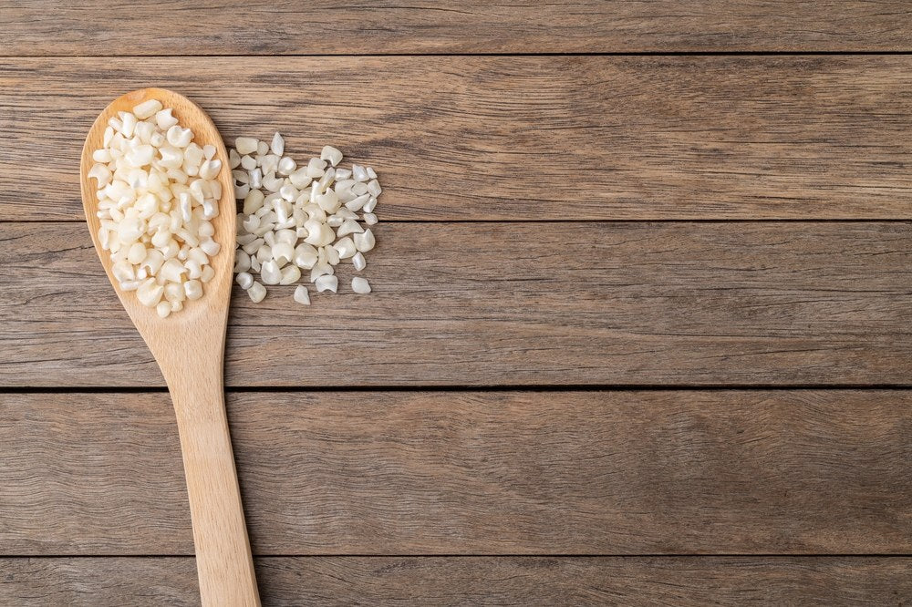 White hominy kernels in a wooden spoon