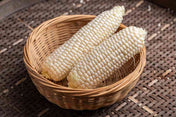 White corn ears in wicker basket for vegetable seeds