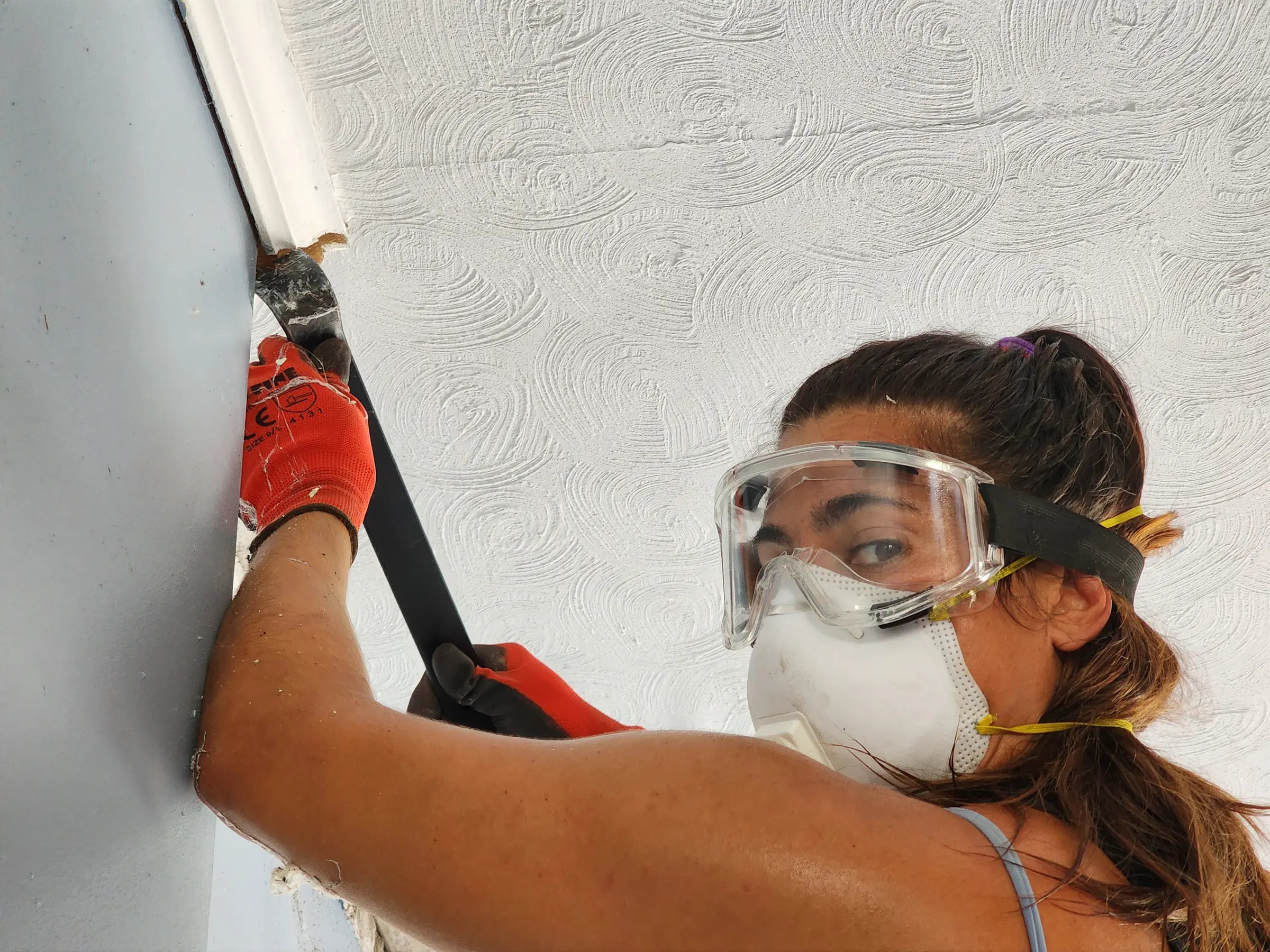 Elizabeth Roach Cain wearing protective goggles and a mask while working on the Colerain building renovation