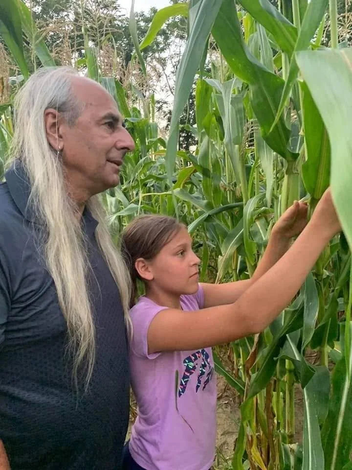 Terry Price and his granddaughter examining Cherokee white flour corn in 2019